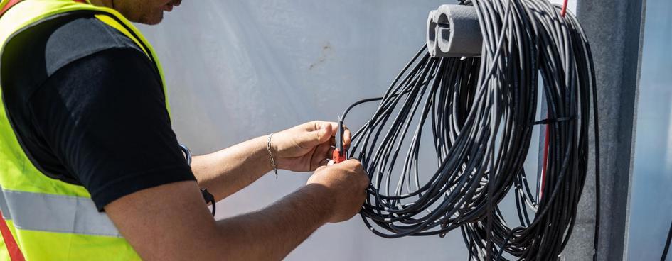 Elektriker arbejder med installationskabler